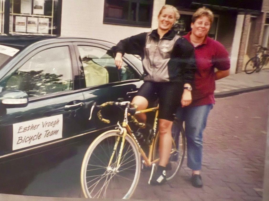 Esther Vroegh met de gele racefiets, naast de auto van het Esther Vroegh Bicycle Team